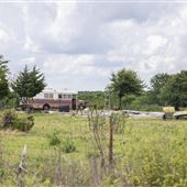 Bus, Concrete Pad, and Cars in Field off Hwy 10